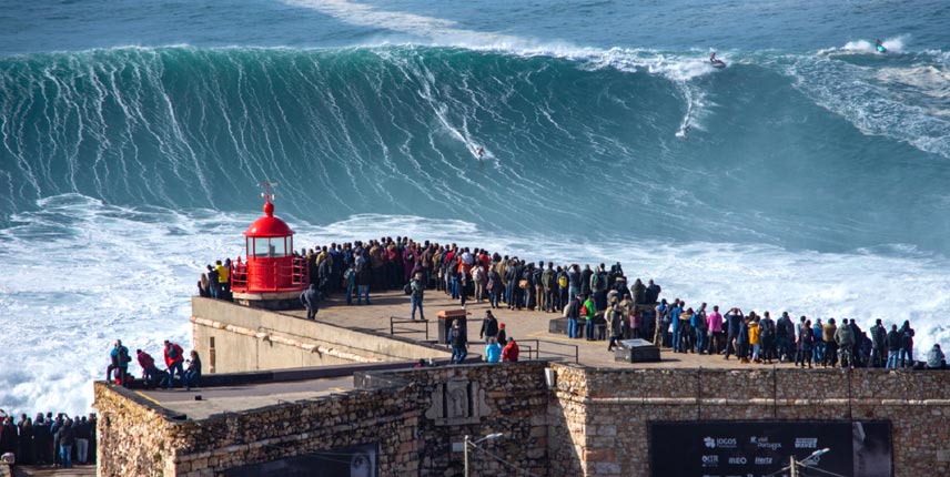 Gente viendo olas gigantes en Nazaré, desde el faro